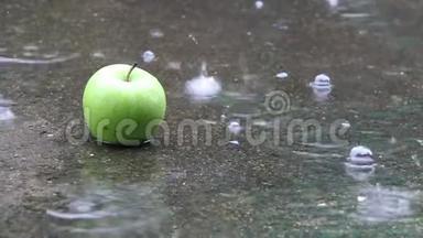 特写镜头拍摄<strong>雨</strong>落在绿色苹果上，放在<strong>水面</strong>上，<strong>雨</strong>路上有气泡。